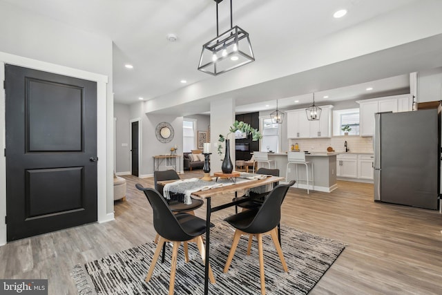 dining space with light hardwood / wood-style floors and sink