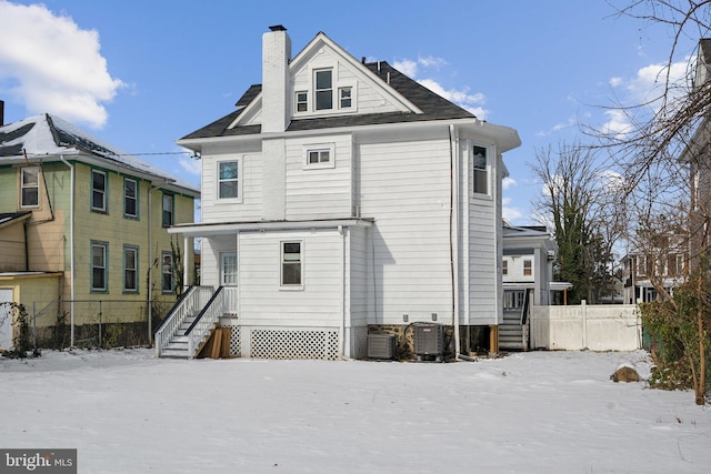 snow covered back of property with central AC unit