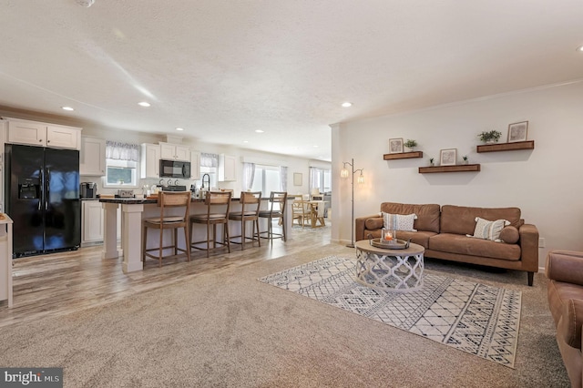 carpeted living room with a textured ceiling and crown molding