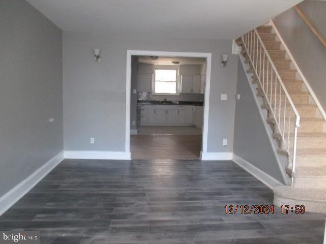 unfurnished living room featuring dark hardwood / wood-style flooring and sink