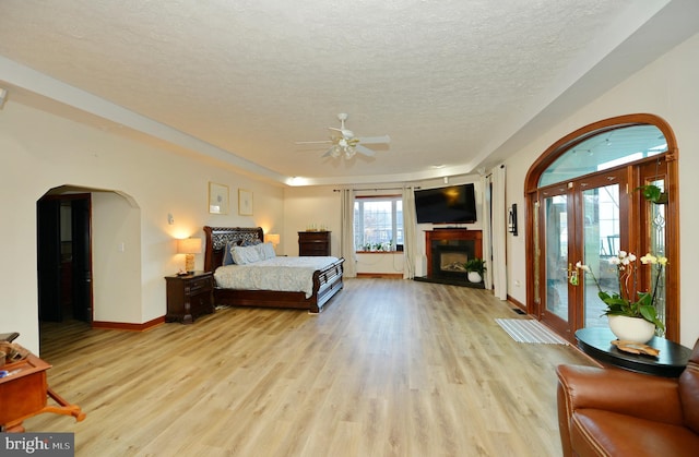 bedroom with access to outside, french doors, ceiling fan, a textured ceiling, and light hardwood / wood-style floors