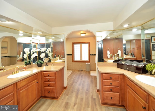 bathroom featuring hardwood / wood-style floors, vanity, and tile walls