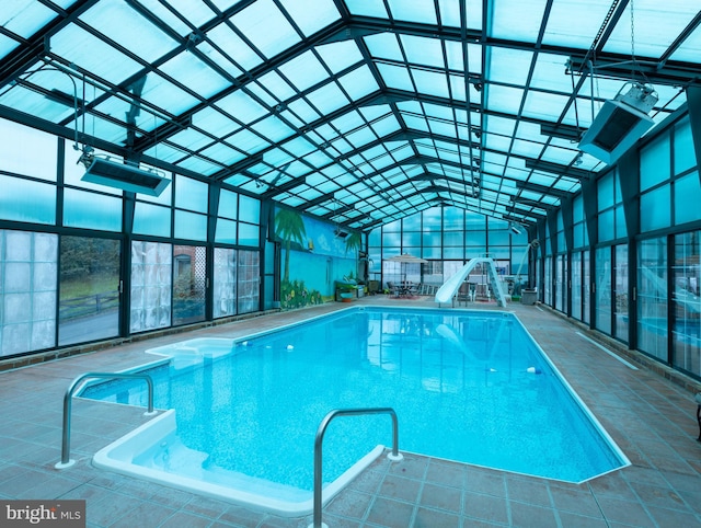 view of swimming pool with a patio area, a lanai, and a water slide