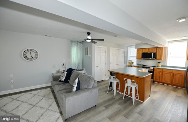 kitchen featuring a kitchen bar, a center island, light hardwood / wood-style floors, and appliances with stainless steel finishes