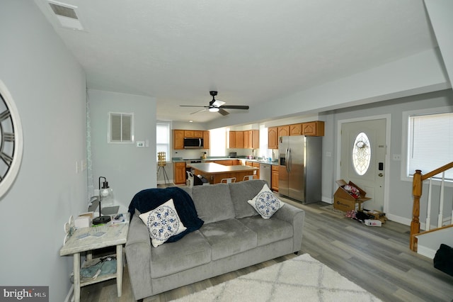 living room featuring ceiling fan and light hardwood / wood-style floors