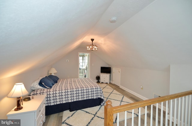 bedroom featuring light hardwood / wood-style floors and vaulted ceiling