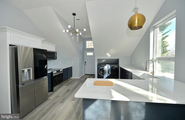 kitchen featuring kitchen peninsula, white cabinetry, stainless steel appliances, and washing machine and dryer