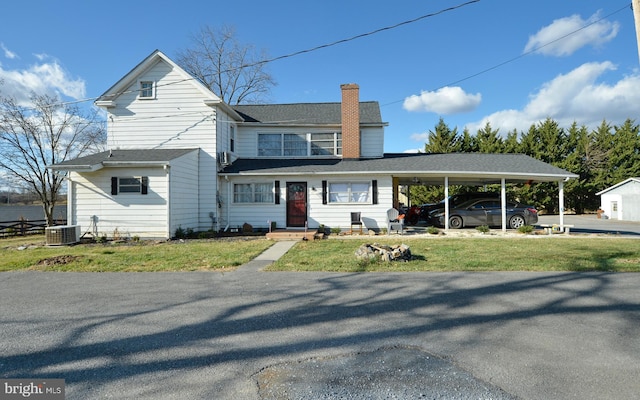 view of front of house with a carport, cooling unit, and a front yard