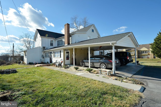 exterior space with a carport and a lawn