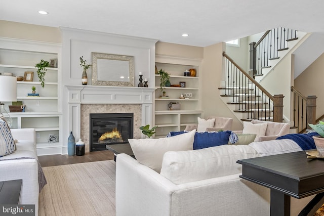 living room featuring a fireplace, hardwood / wood-style floors, and built in shelves