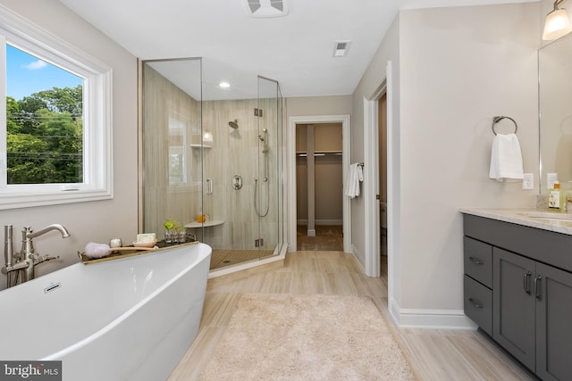 bathroom with vanity, plus walk in shower, and hardwood / wood-style flooring