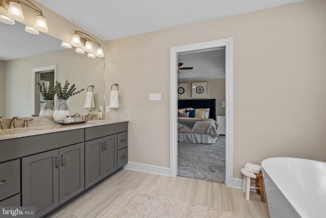 bathroom featuring vanity, ceiling fan, and a bath