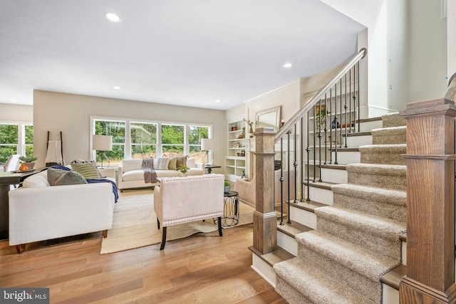 living room with built in features and light hardwood / wood-style floors