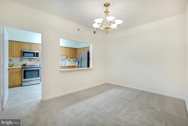 interior space featuring light carpet, sink, a chandelier, and a textured ceiling