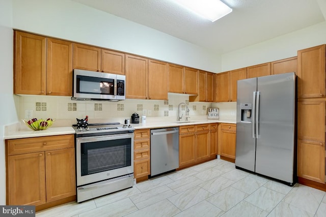 kitchen featuring stainless steel appliances, tasteful backsplash, and sink