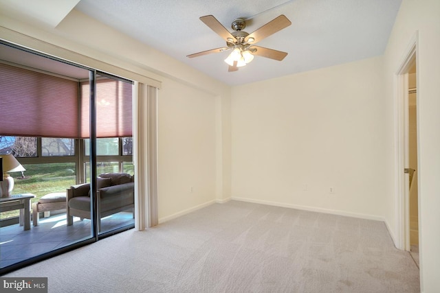 spare room featuring light colored carpet and ceiling fan