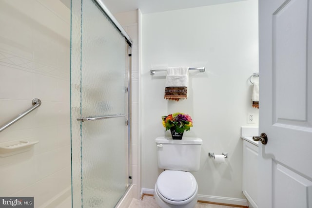 bathroom featuring toilet and a shower with shower door