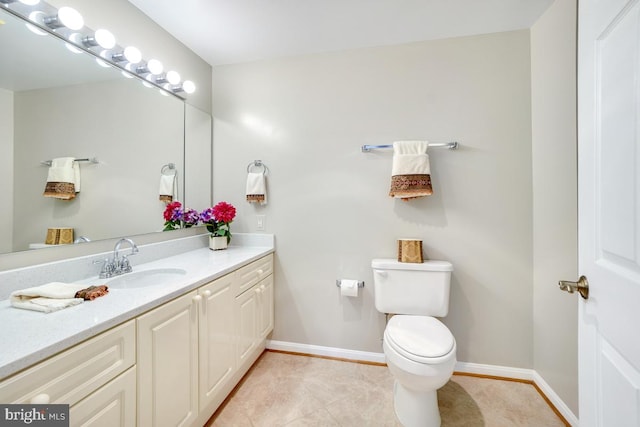 bathroom with tile patterned flooring, vanity, and toilet