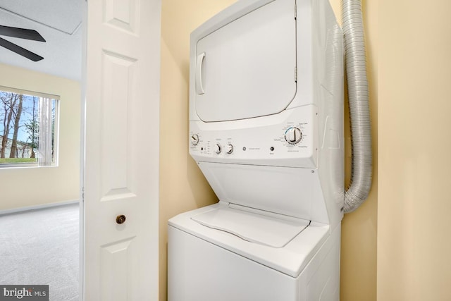 washroom with carpet floors, stacked washing maching and dryer, and ceiling fan