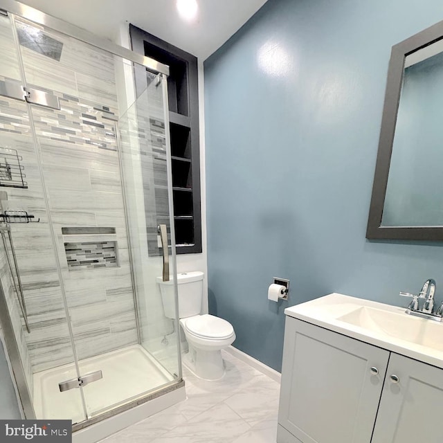 bathroom featuring a stall shower, baseboards, toilet, marble finish floor, and vanity