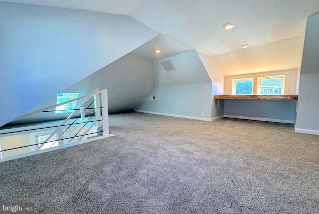 bonus room featuring lofted ceiling, carpet flooring, visible vents, and baseboards