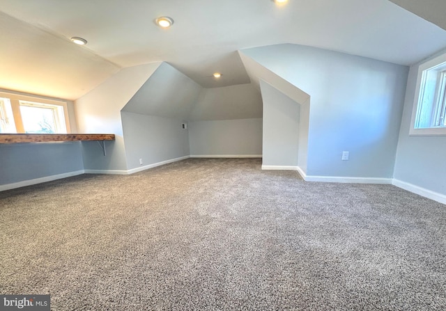 bonus room featuring carpet, plenty of natural light, baseboards, and vaulted ceiling