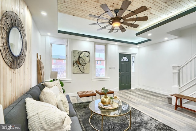 living room featuring a raised ceiling, ceiling fan, hardwood / wood-style floors, and wood ceiling