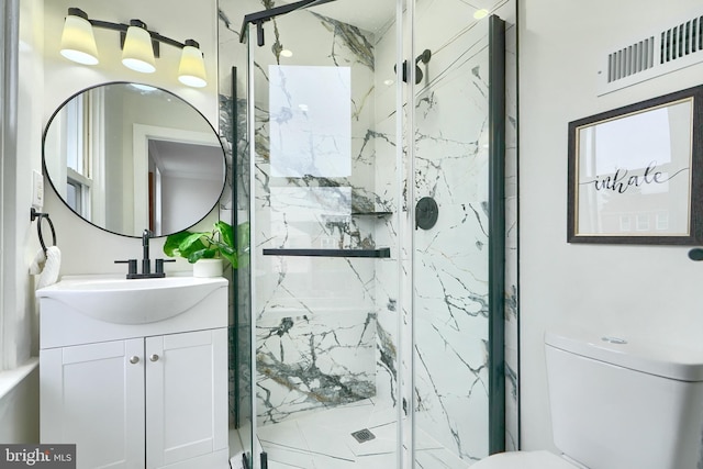 bathroom with vanity, a shower with shower door, and toilet