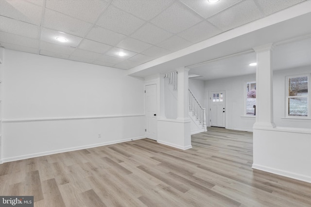 basement with a drop ceiling and light wood-type flooring