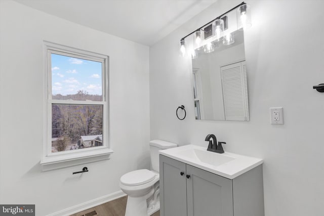 bathroom with hardwood / wood-style flooring, vanity, and toilet