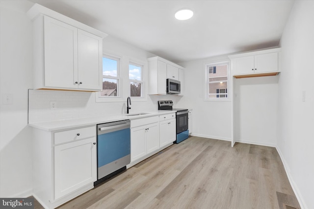 kitchen with backsplash, white cabinetry, sink, and appliances with stainless steel finishes