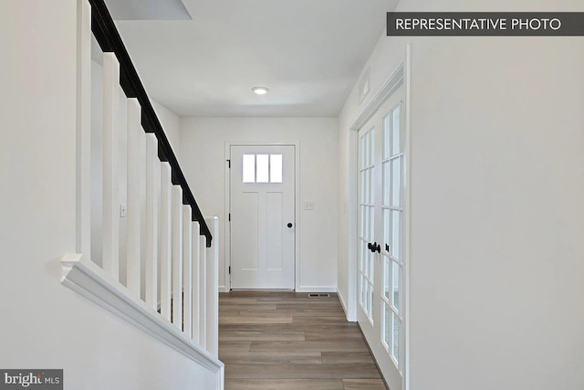 foyer entrance with french doors and light hardwood / wood-style flooring