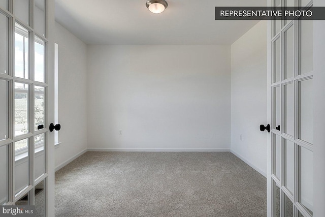 spare room with carpet flooring and french doors