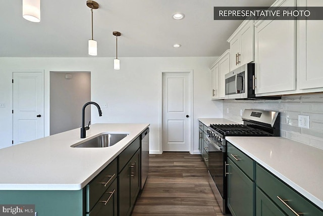 kitchen with appliances with stainless steel finishes, sink, pendant lighting, a center island with sink, and white cabinets