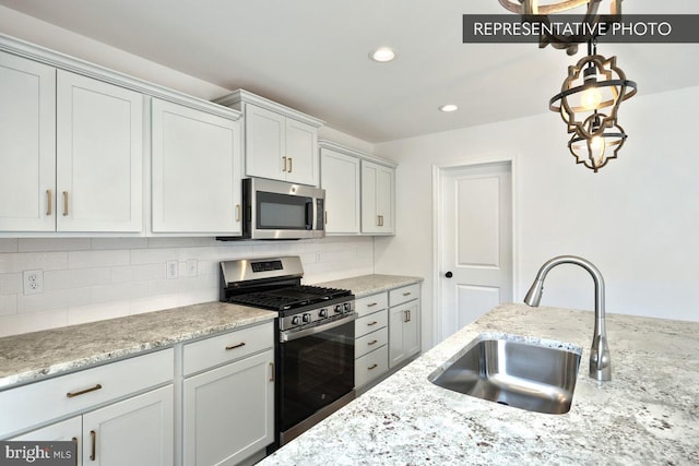 kitchen with decorative backsplash, stainless steel appliances, white cabinets, and sink