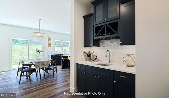 kitchen featuring sink, an inviting chandelier, tasteful backsplash, dark hardwood / wood-style flooring, and decorative light fixtures