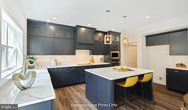 kitchen with a center island, sink, stainless steel appliances, dark hardwood / wood-style flooring, and backsplash