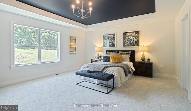 bedroom featuring a tray ceiling, light carpet, and a notable chandelier