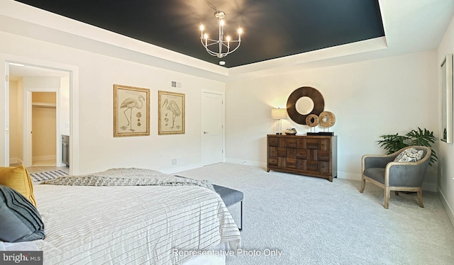 carpeted bedroom featuring a chandelier, connected bathroom, and a tray ceiling