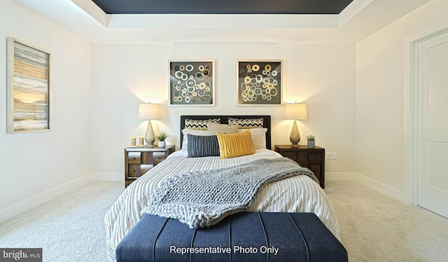 carpeted bedroom with a tray ceiling