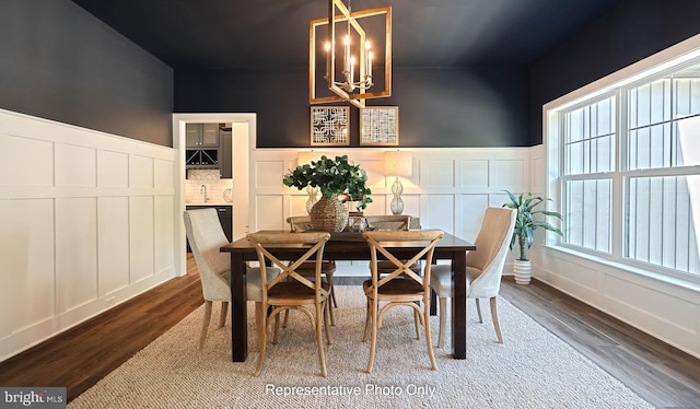 dining area with a chandelier and dark wood-type flooring