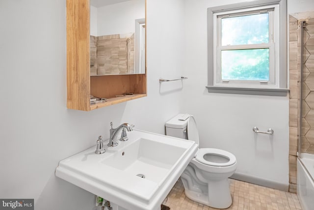 full bathroom with tiled shower / bath combo, toilet, and sink