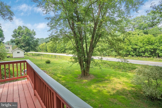 wooden terrace featuring a lawn