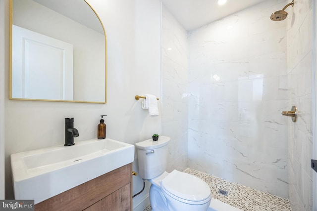 bathroom featuring vanity, toilet, and tiled shower