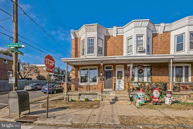 townhome / multi-family property with a porch and cooling unit