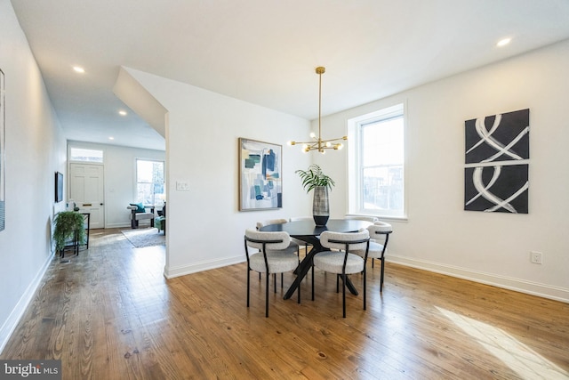 dining space with wood-type flooring and a chandelier