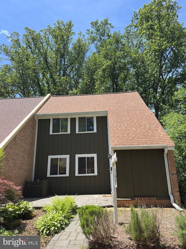 11152 Forest Edge Dr, Reston, VA 20190 - view of front of property featuring board and batten siding, roof with shingles, and brick siding