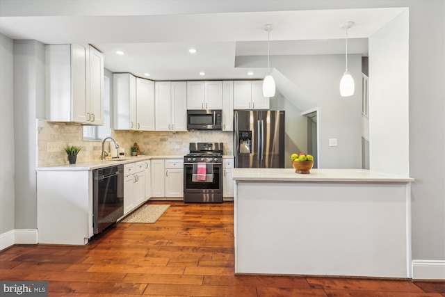 931 Farragut St NW, Washington, DC 20011 - kitchen with decorative backsplash, dark wood-style flooring, appliances with stainless steel finishes, light countertops, and white cabinets