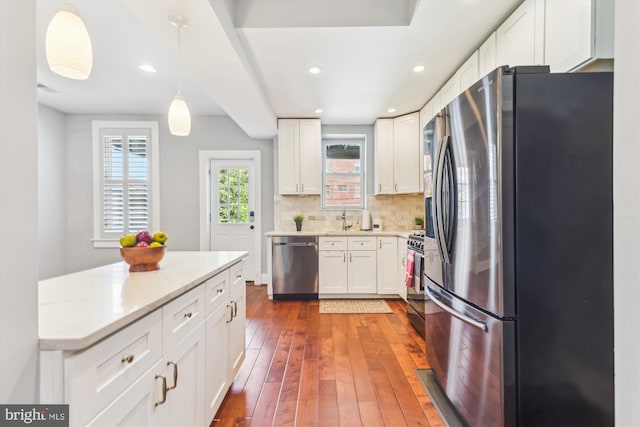 931 Farragut St NW, Washington, DC 20011 - kitchen with decorative backsplash, appliances with stainless steel finishes, hardwood / wood-style flooring, a sink, and white cabinets
