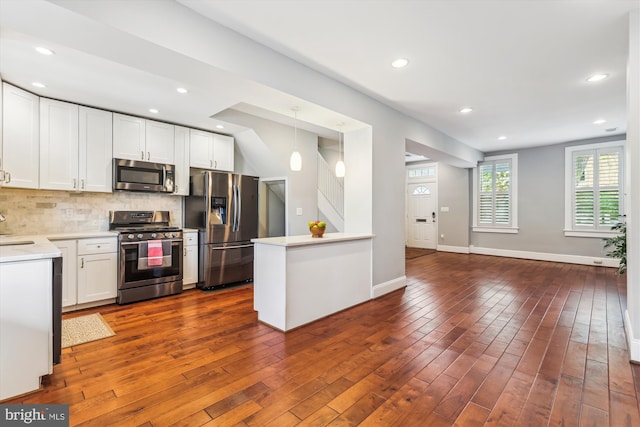931 Farragut St NW, Washington, DC 20011 - kitchen with appliances with stainless steel finishes, decorative backsplash, dark wood-style floors, and white cabinetry
